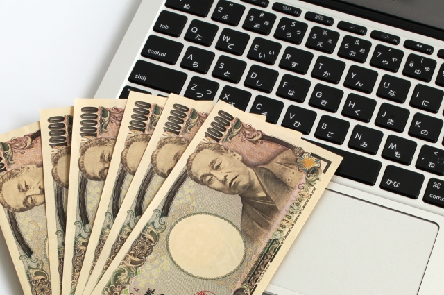 6枚の1万円札とパソコン