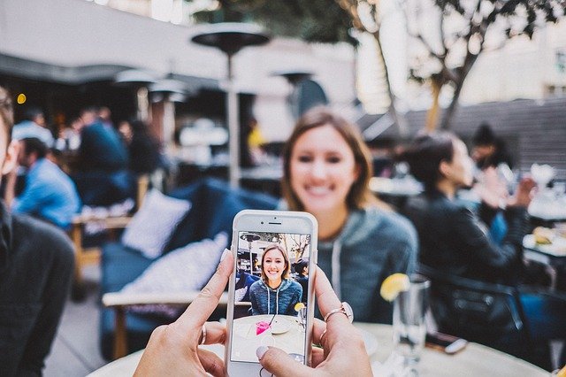 スマホのカメラで女性を撮っている様子